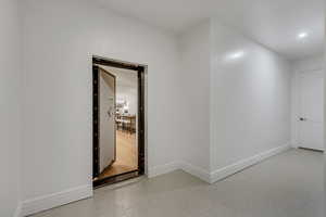 Corridor featuring dark speckled floor and recessed lighting