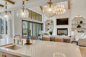Kitchen with a sink, built in features, beamed ceiling, open floor plan, and light countertops