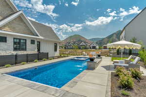 View of pool with a mountain view, a patio area, a fenced backyard, an in-ground hot tub, and an outdoor hangout area