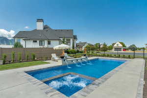 View of pool featuring a fenced backyard, a patio, and a pool with connected hot tub
