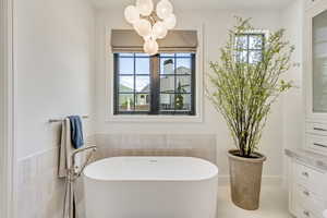 Bathroom with a soaking tub, plenty of natural light, and a chandelier