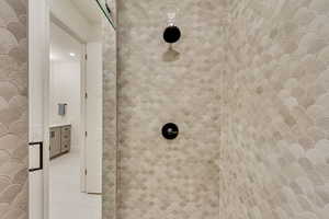 Bathroom view of tiled shower and vanity
