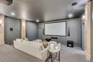 Home theater featuring carpet flooring, recessed lighting, and ornate columns