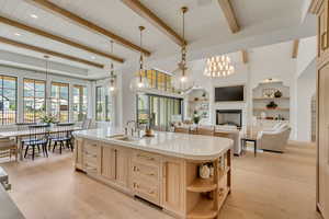 Kitchen with a sink, light brown cabinets, open shelves, light countertops, and light wood-type flooring