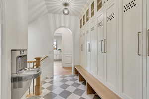 Mudroom featuring light flooring and arched walkways