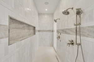Bathroom with a tile shower and tile walls