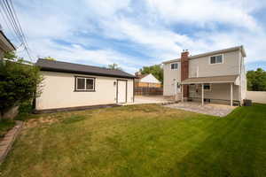 Back of house with a patio, central air condition unit, an outbuilding, and a chimney
