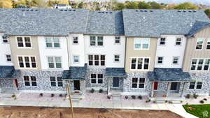 View of front of property featuring stone siding and a high end roof