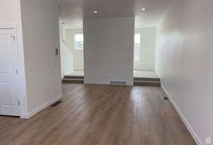 Empty room featuring wood finished floors, baseboards, and recessed lighting