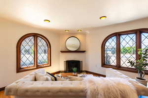 Living area featuring baseboards, wood finished floors, and a fireplace with raised hearth