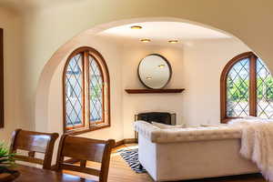 Living room featuring arched walkways, wood finished floors, and baseboards