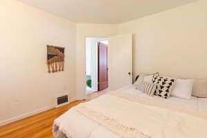 Bedroom with light wood finished floors and baseboards