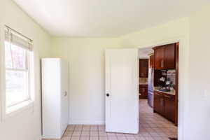 Unfurnished room featuring light tile patterned floors and baseboards