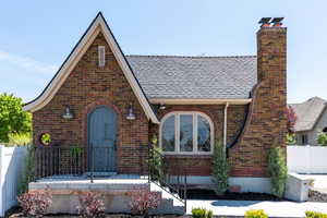 English style home with brick siding and a chimney