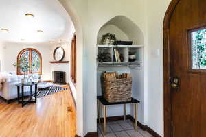 Entrance foyer with arched walkways, plenty of natural light, and wood finished floors