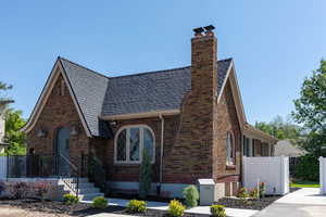 View of front of home with a chimney and brick siding