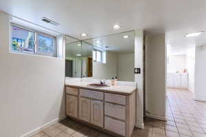 Bathroom featuring tile patterned flooring, vanity, baseboards, and recessed lighting