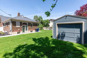 View of yard with central AC unit, a detached garage, and an outbuilding
