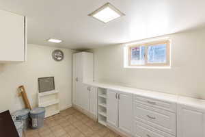 Kitchen with white cabinetry, light countertops, and open shelves