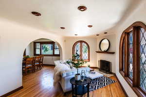 Living area featuring healthy amount of natural light, wood finished floors, baseboards, and arched walkways