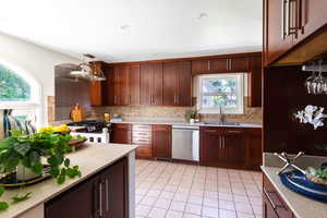 Kitchen featuring stainless steel appliances, a sink, light countertops, and backsplash