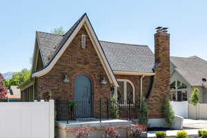Tudor home with brick siding, a chimney, and a shingled roof