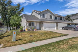 View of front of property featuring concrete driveway, an attached garage, and a shingled roof