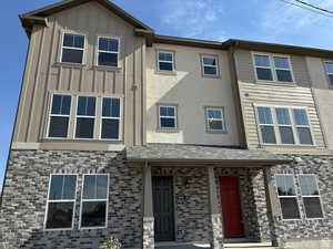 View of front of house featuring board and batten siding and brick siding