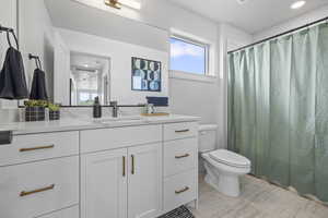 Full bathroom featuring toilet, vanity, and a shower with curtain