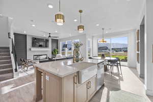 Kitchen featuring stainless steel dishwasher, a sink, light brown cabinets, recessed lighting, and a ceiling fan