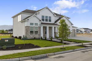 Craftsman-style home with driveway, stone siding, a front lawn, roof with shingles, and a garage