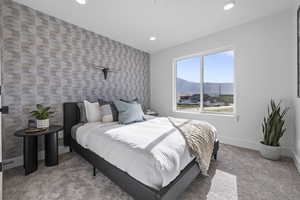 Carpeted bedroom with recessed lighting, an accent wall, baseboards, and a mountain view
