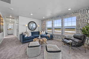 Living area with carpet, healthy amount of natural light, baseboards, recessed lighting, and wallpapered walls