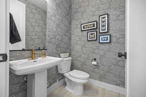 Half bath with toilet and wood finished floors