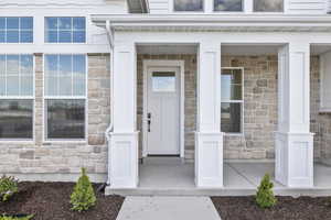 Entrance to property featuring stone siding