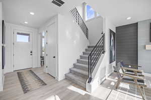 Entryway featuring stairs, light wood-type flooring, recessed lighting, and baseboards