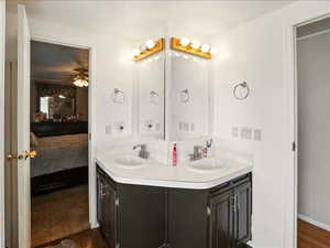 Ensuite bathroom with double vanity, wood finished floors, and ceiling fan