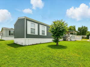 View of side of home featuring a yard