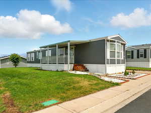 Manufactured / mobile home featuring a front lawn and a porch