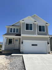 View of front of home featuring an attached garage, driveway, a porch, and brick siding