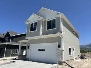 View of front facade featuring a garage, driveway, cooling unit, and a mountain view