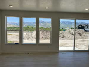Entryway with a mountain view, baseboards, wood finished floors, recessed lighting, and a textured ceiling