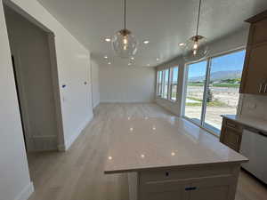 Unfurnished dining area featuring light wood-style flooring, baseboards, a mountain view, and recessed lighting