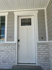 Property entrance featuring brick siding