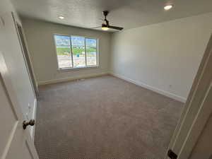Unfurnished bedroom featuring baseboards, light colored carpet, recessed lighting, ceiling fan, and a textured ceiling