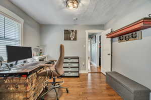 Office space featuring wood finished floors and a textured ceiling