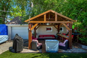 View of patio with an outdoor hangout area, grilling area, a garage, a gazebo, and driveway