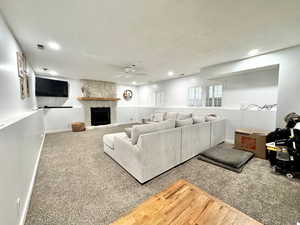 Living area with ceiling fan, carpet flooring, recessed lighting, a fireplace, and baseboards