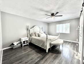 Bedroom featuring baseboards, dark wood finished floors, ceiling fan, and a textured ceiling