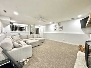 Carpeted living room with stairs, recessed lighting, baseboards, and ceiling fan